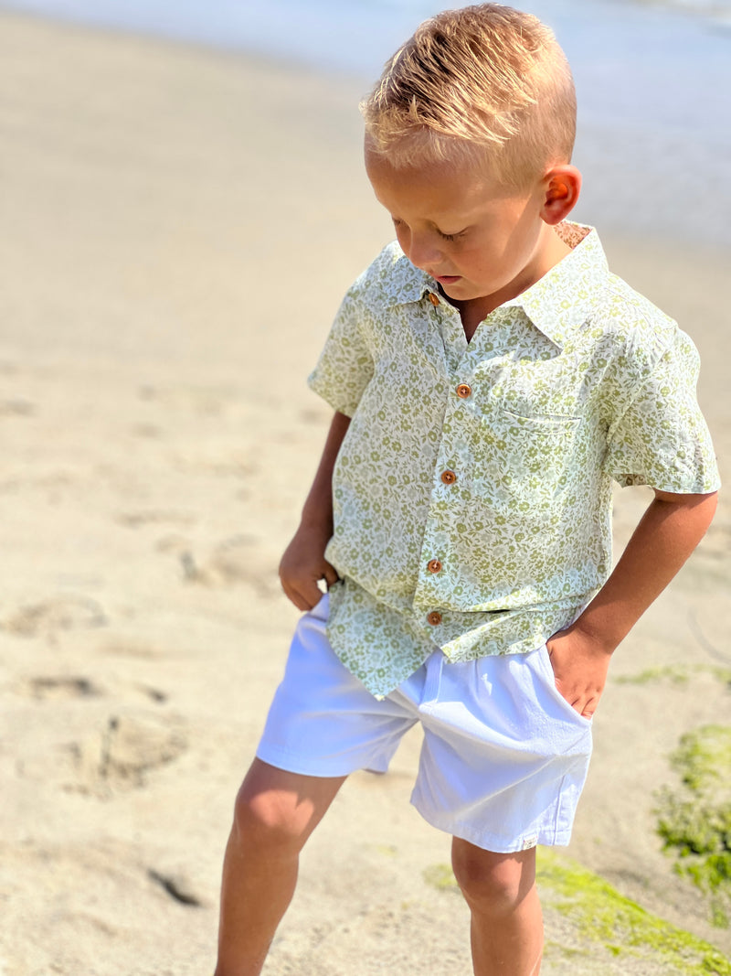 blonde boy with blue eyes wearing the green floral woven shorts and white gauze shorts.