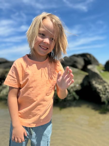 Boy, wearing, tangerine, SLUB, tee,       pocket, blue, shorts, pockets, long,            fair, hair, at, the, beach, henry. 