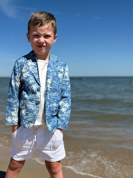  Boy on shoreline, in Chambray Hawaiian Jacket White Tee White Shorts all by Henry.