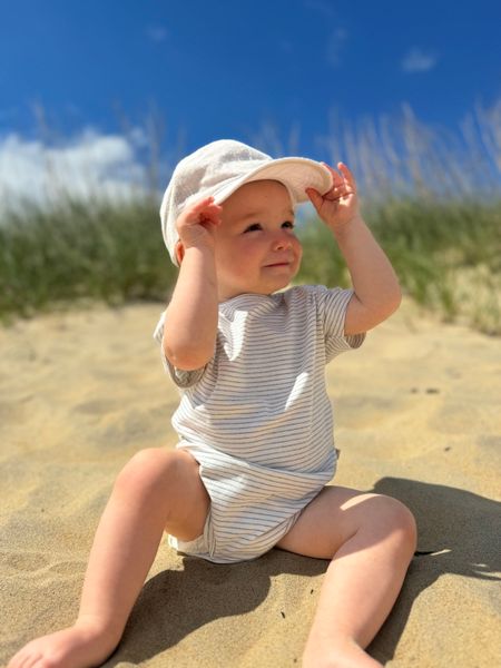 Nautical, striped, triple, pack, onesies, little, baby, wearing, woven, cap, sitting, in, the, sand, summer,  henry.           