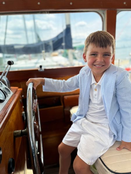 Boy sat in pilots seat wearing Blue Stripe, Stripped, Stripes, Seersucker Jacket, White Polo, White Shorts