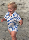 Child wearing a Royal and white striped Jersey onesie on a sandy beach