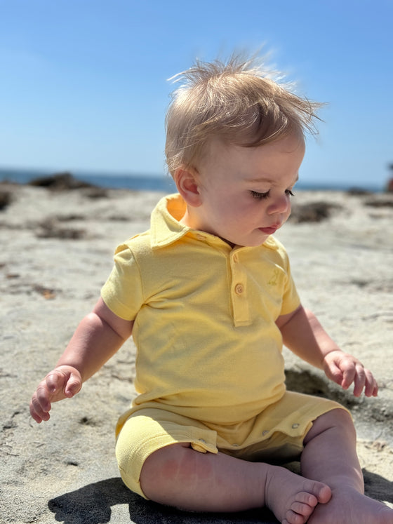 lemon, pique, polo, romper, collar,              button, buttons, little, boy, sitting, in, the, sand, holding, a, shell, spring, summer, henry.