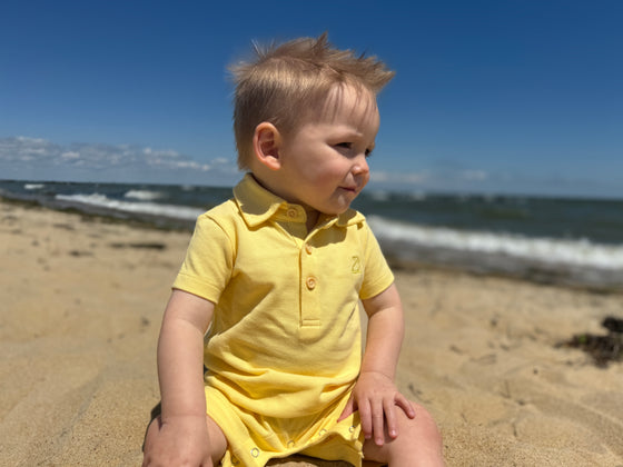 lemon, pique, polo, romper, collar,              button, buttons, little, boy, sitting, in, the, sand, holding, a, shell, spring, summer, henry.