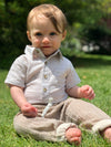 Beige, pant, pants, shirt, light, gauze, 
   baby, onesie button,  buttons,  collar, pocket, brown, hair, little, boy, sitting,  in, field, casual, henry.            